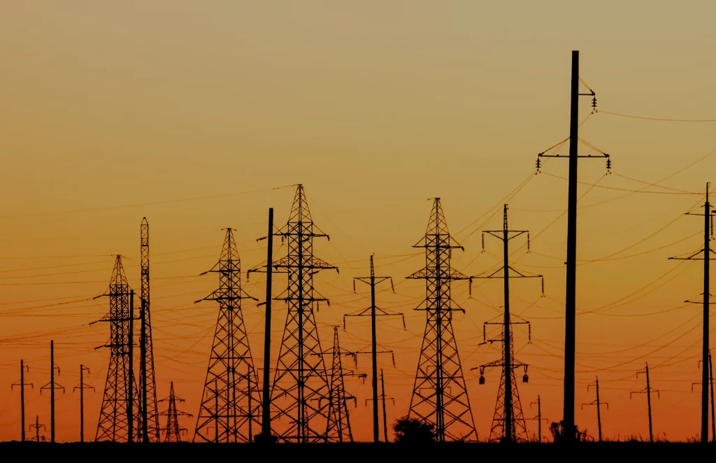 Silhouette of a power grid with multiple powerline towers